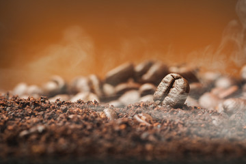 Close up Coffee beans over the cofee powder with smoke