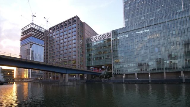 View of London's Canary Wharf Financial District Offices with DLR (Docklands Light Railway) Train departing Heron Quays Station.