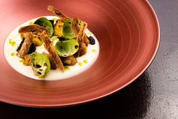 Corn dumplings on cauliflower puree, Brussel sprouts, crunchy potato skins,