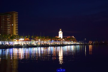 paesaggio notturno del porto di Malaga con riflesso nell'acqua del mare delle luci dei ristoranti e negozi che sono una grande attrazione turistica