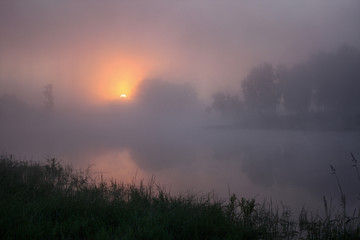 The sun rises early in the morning in the fog
