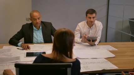 Atractive entrepreneur in virtual reality glasses. Group of young developers working on drawings in modern glass office. Diverse business team in meeting room. Slow motion - Powered by Adobe