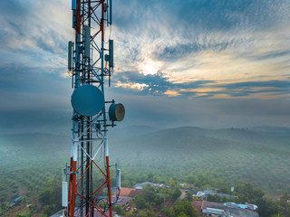 Aerial view of telecommunication tower with sunrise background.