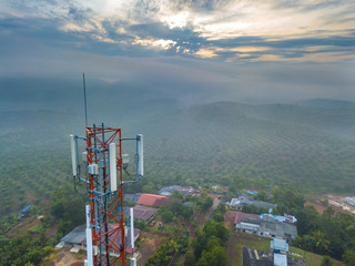 Aerial view of telecommunication tower with sunrise background.