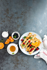 Sweet pancakes wrapped with fresh berries, crepes with blueberry and raspberry on breakfast, top view