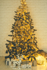 Christmas tree with golden decoration and many gifts underneath