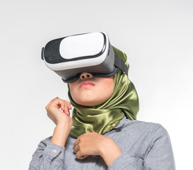 Veiled teenager wearing virtual reality box with white background.