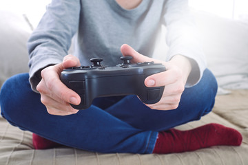 man holding a joystick controllers while playing a video games at home