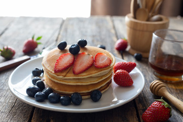 Delicious pancakes with Strawberry and blueberry on wooden table.top view
