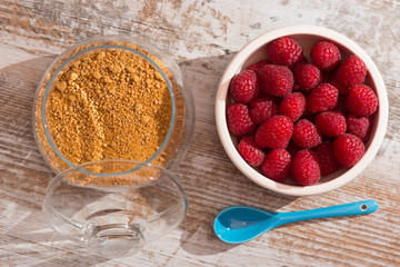 Bowl of raspberries on wooden background