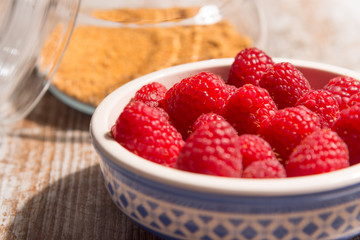 Bowl of raspberries on wooden background