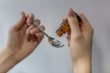 dropper and spoon, hands holding medicine instument, dose for treatment