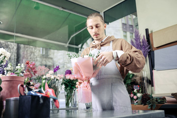 Attentive florist composing tender bouquet for little princess