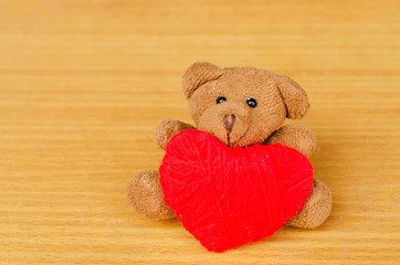 Close up of Brown teddy with red heart made from thread yarn for Valentines day concept
