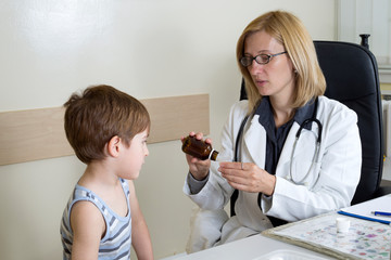 Female Doctor Pouring A Cough Syrup Into Spoon  In The Consulting Room