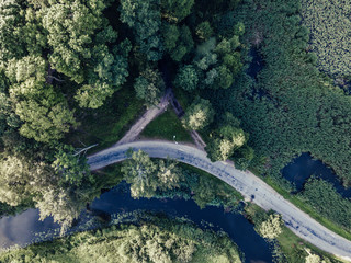 Aerial Photo of Road going by the River under the Trees, Top Down View in Early Spring on Sunny Day...