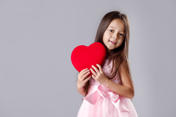 cute little girl in a pink dress holding a paper heart