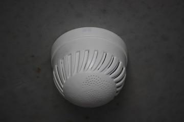 smoke detector on a gray wall in a new building, fire safety. protection of the apartment or house from fire and smoke. take care