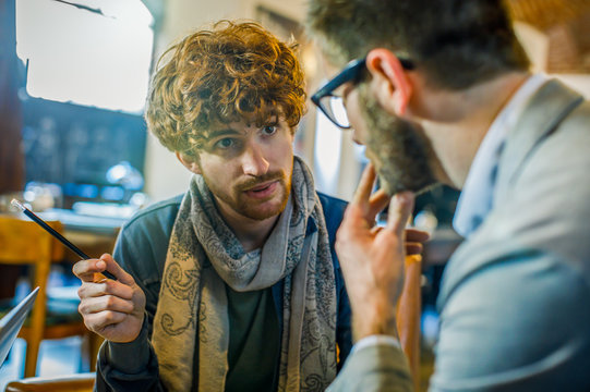 Man talking strategy with client or colleague.Group of multiethnic people having business team meeting in restaurant lounge.Teamwork,corporate,diversity and social concepts.