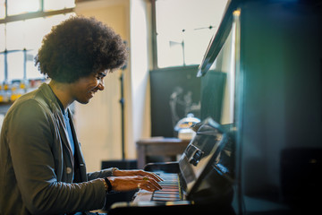 Afro american man playing piano at restaurant lounge