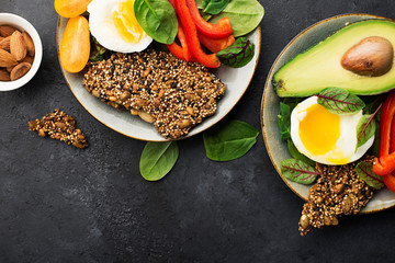 Keto bowl. Ketogenik diet snack. Cereal crackers without flour, paprika, avocado, eggs, spinach, nuts for a healthy diet. Top view