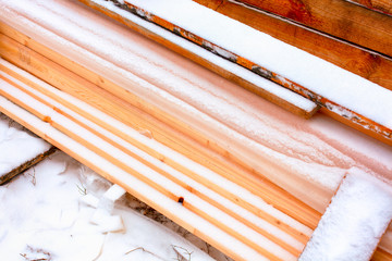 Stack of lumber covered in snow.