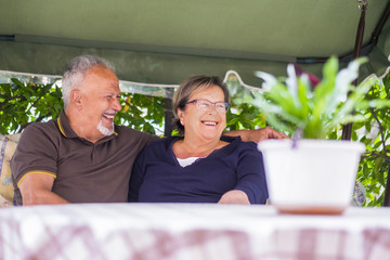 nice couple of beautiful caucasian senior 70 years old sit outdoor at home having fun with smiles...