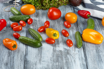 Tomatoes, cucumbers, green salad on a wooden background with space for the text.