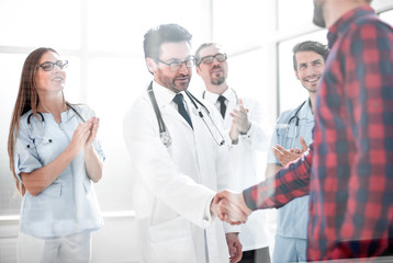 Fototapeta premium Thankful patient shaking doctors hand