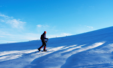 Fototapeta na wymiar active senior woman snowshoeing in the Allgaeu Alps near Oberstaufen, Bavaria, Germany
