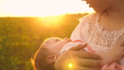 a little baby sleeps in arms of his mother, at sunset, slow-motion shooting