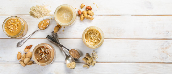 Selection of nut butters - peanut, cashew, almond and sesame seeds, copy space