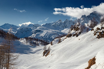 Fototapeta na wymiar Panoramic view of the sunny snow-covered landscape of the Alpe Sangiatto above the Alpe Devero in Piedmont, Italy.