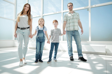 Fototapeta premium parents with small children standing in the new house