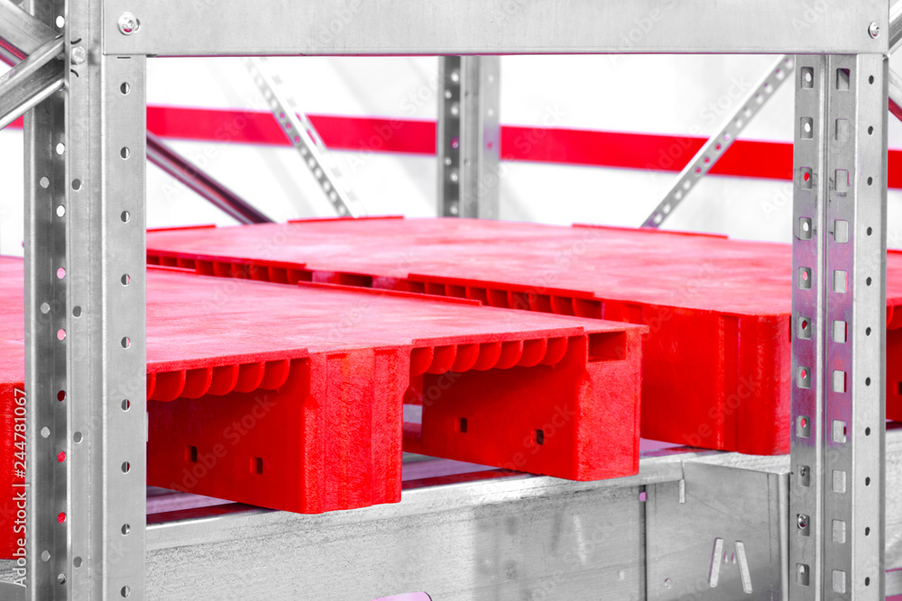 Poster Empty red plastic pallets on racks in an automated warehouse complex