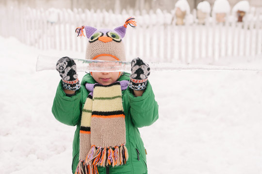 winter portrait of a little boy with an icicle