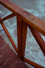  fragment of a wooden bridge against the sea during a storm