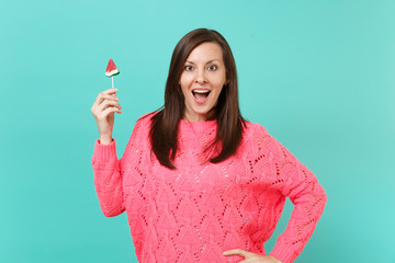 Surprised young woman in knitted pink sweater keeping mouth wide open, hold in hand watermelon...