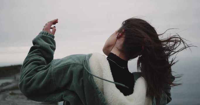 In amazing place of Cliffs of Moher , woman standing on the shore of Cliffs and have meditation time , on a windy day. 4k