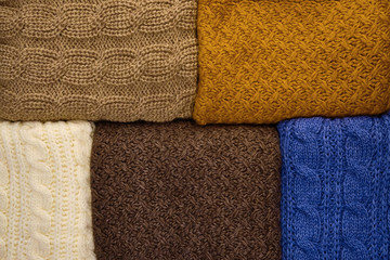Fototapeta na wymiar Stack of Warm knitwear close-up. Woolen knit texture as background