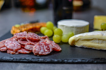 Käse und Wurst auf Schieferplatte in der Küche mit Weinkorken