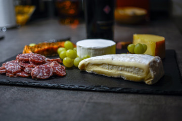 Käse und Wurst auf Schieferplatte in der Küche mit Weinkorken