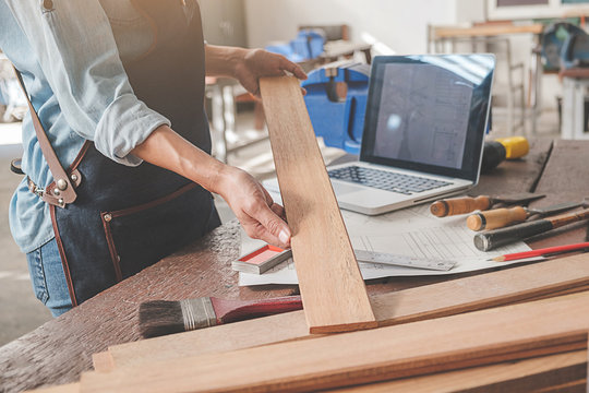 Carpenter working with equipment on wooden table in carpentry shop. woman works in a carpentry shop.