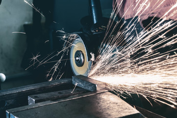 The working mechanic cleans the metal by grinding