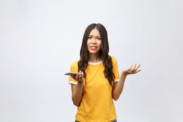 Portrait of a furious asian woman talking on mobile phone isolated over white background