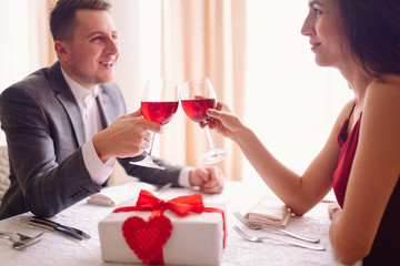 Valentine's Day concept. Happy couple in love with. A young loving couple celebrating Valentine's Day in the restaurant. Lovers give each other gifts. Romance restaurant for Valentine's Day- concept.