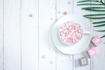 Pink square wood with white numbers 1 and 4.Gray square wood with white letters FEB.February 14 Valentine's Day.White coffee cup on wooden floor.Many small hearts, white and pink