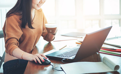 Close up business woman using computer for working in office with coffee on wooden table. Selective...