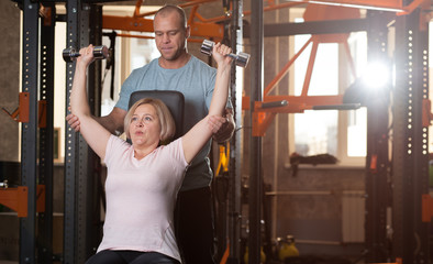 Personal trainer man corrects instructions