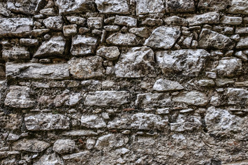 Stone wall background, dark grey limestone texture